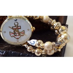 Watch with a sporty looking anchor with a touch of red in middle of a round, gold watch face.